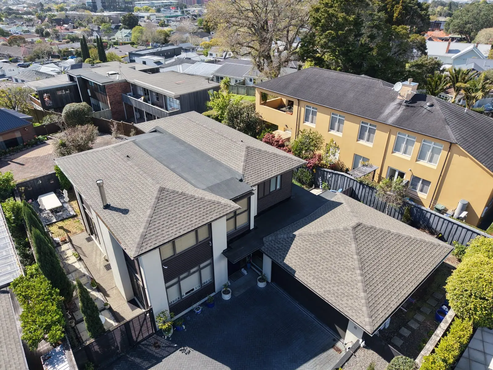 Aerial view of completed asphalt shingle roofs in an Auckland suburb