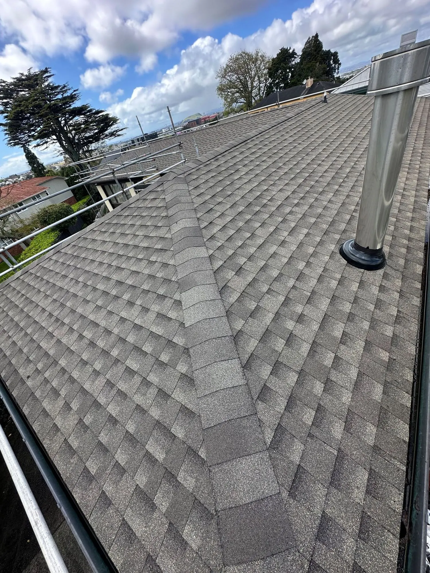 Completed asphalt shingle roof viewed up the slope on an Auckland home
