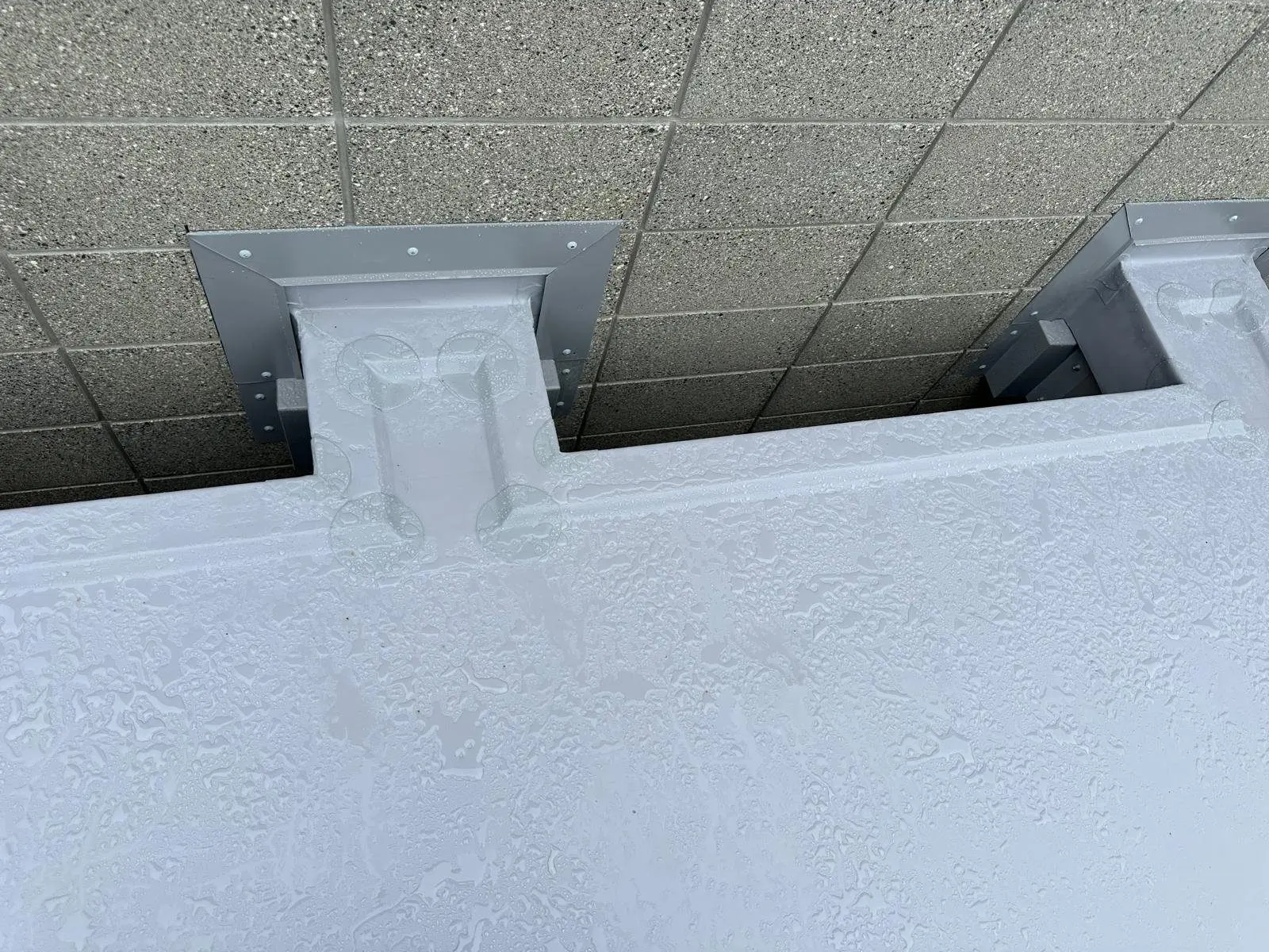 Custom scupper flashing installed through a block wall