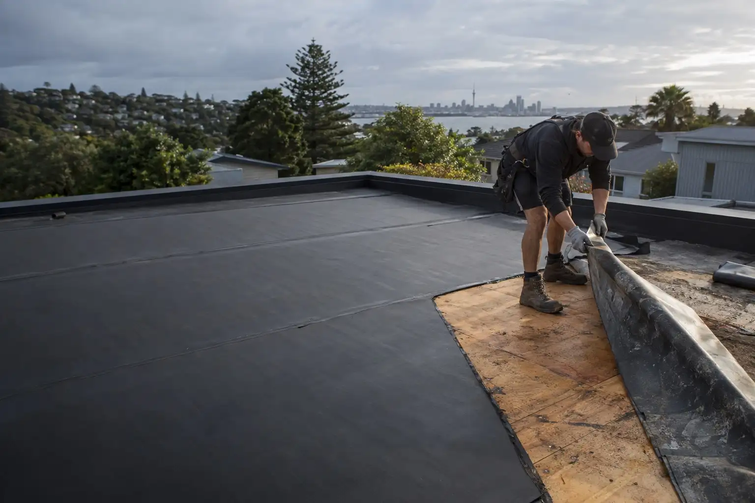 Roofer replacing aged butynol membrane on an Auckland flat roof