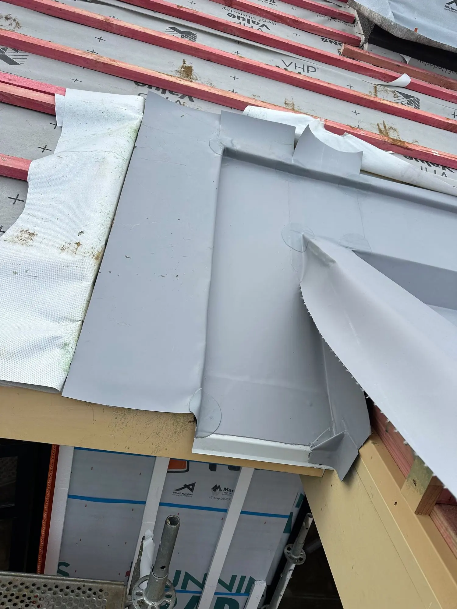 Membrane saddle flashing formed behind a roof penetration