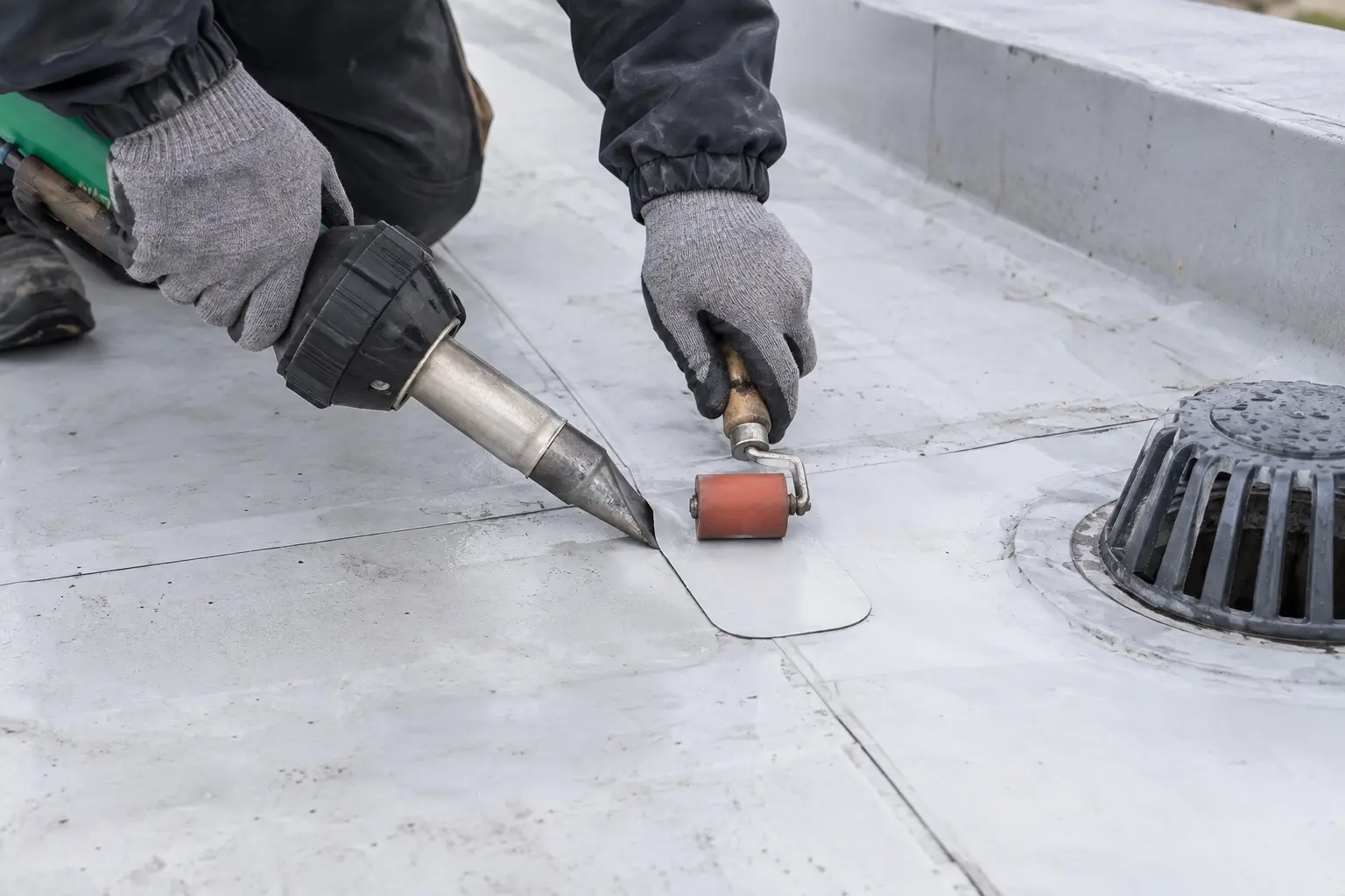 Specialist hot-air welding a flat membrane roof repair in Auckland