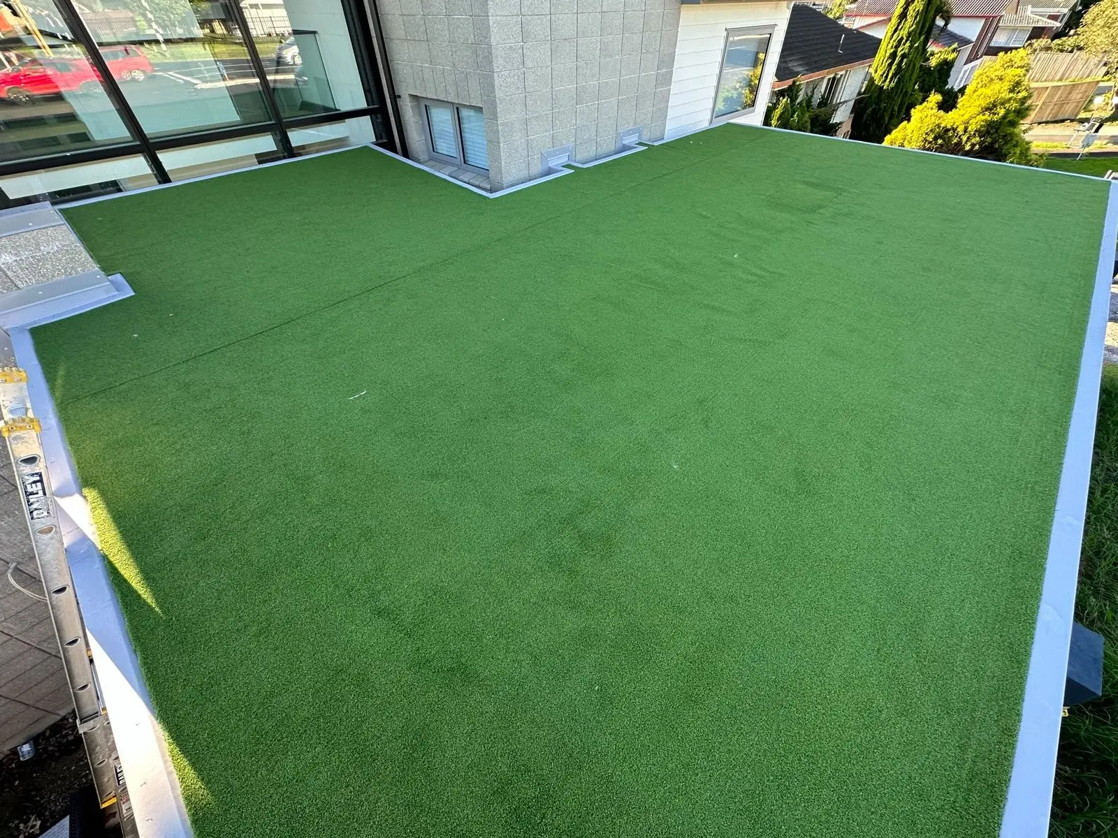 Wide view of a turf-covered membrane roof deck in Auckland